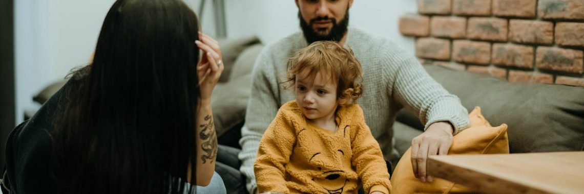 a man sitting on a couch next to a little girl